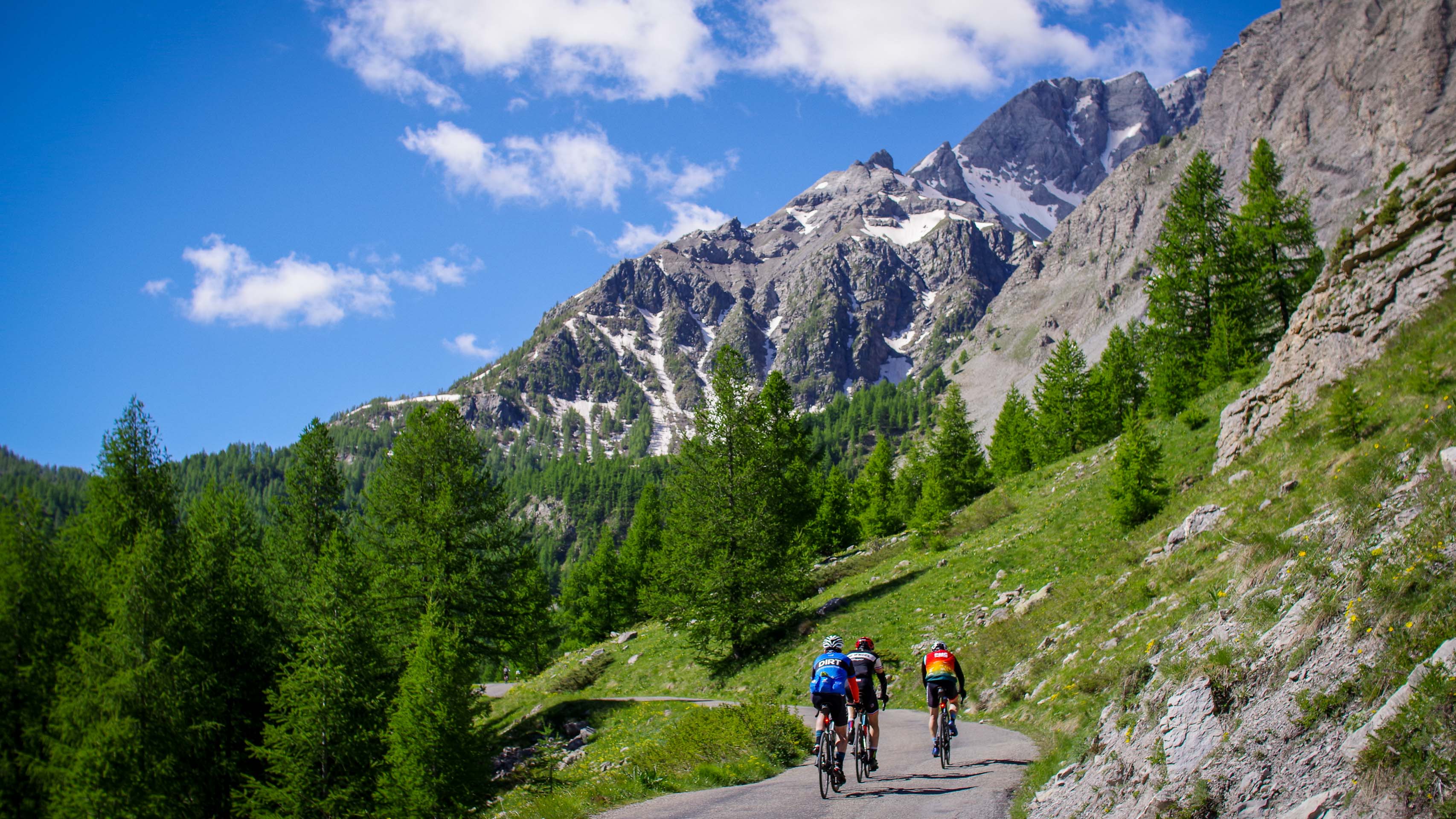 trois cyclistes en pleine ascension dans une ambiance 