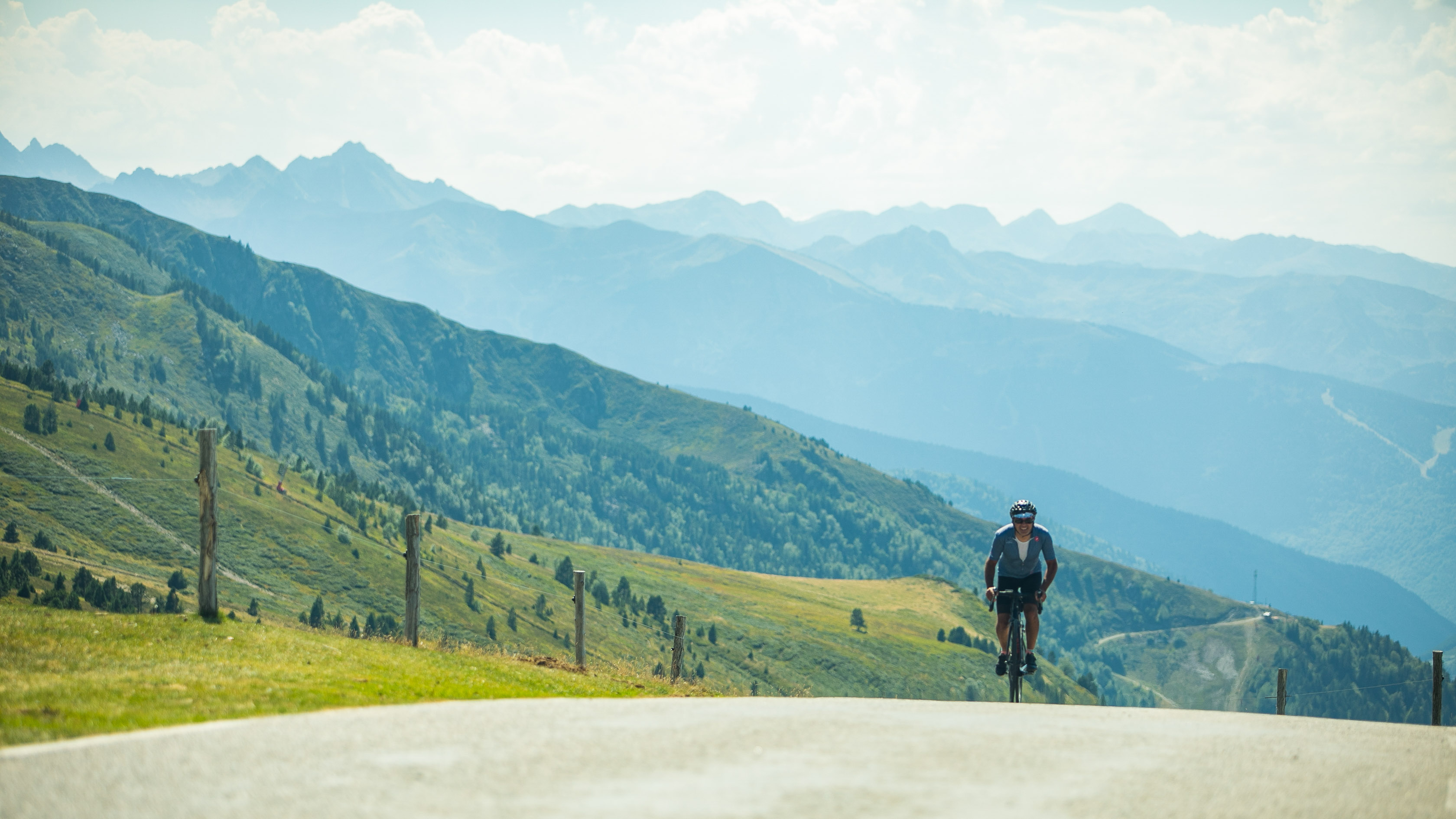 un cycliste arrive en haut d'un col