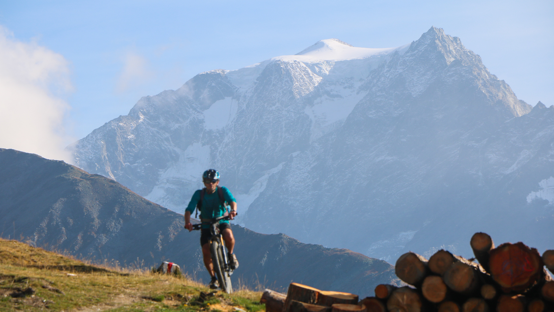 Homme à VTT sur un plateau de Haute-Montagne avec en arrière plan le Grand Combin