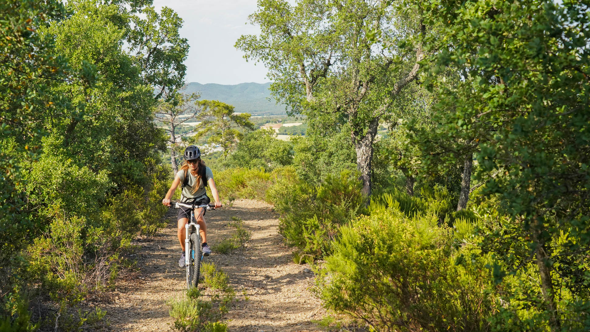 femme à vtt sur un chemin en forêt en Espagne