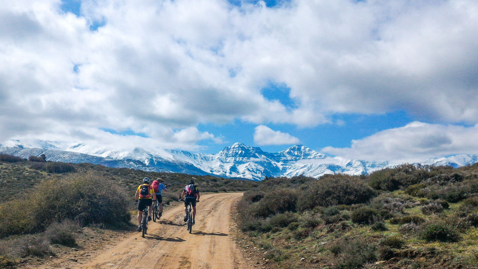 vttistes sur un piste en direction de la sierra nevada enneigée