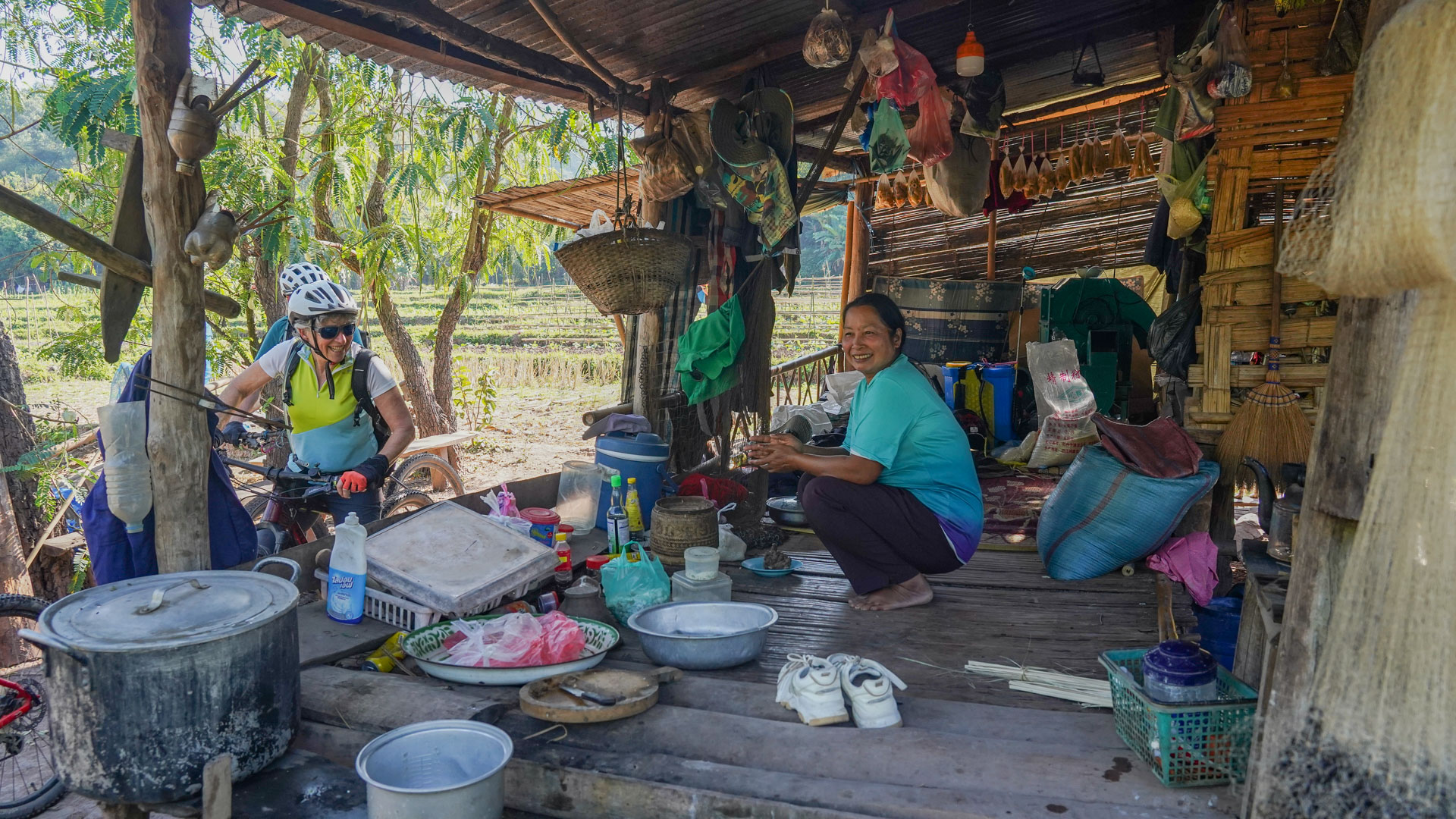 un voyageur à vélo s'arrête discuter avec un marchand au Laos