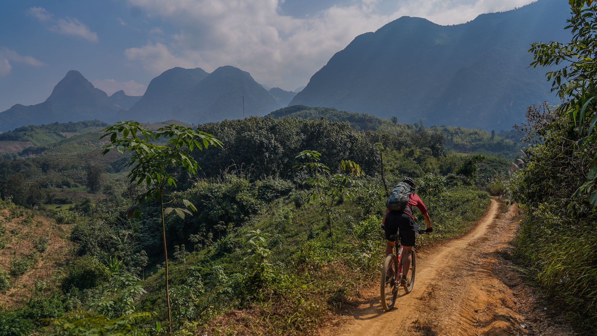 un VTT roule au milieu des montagnes du Laos