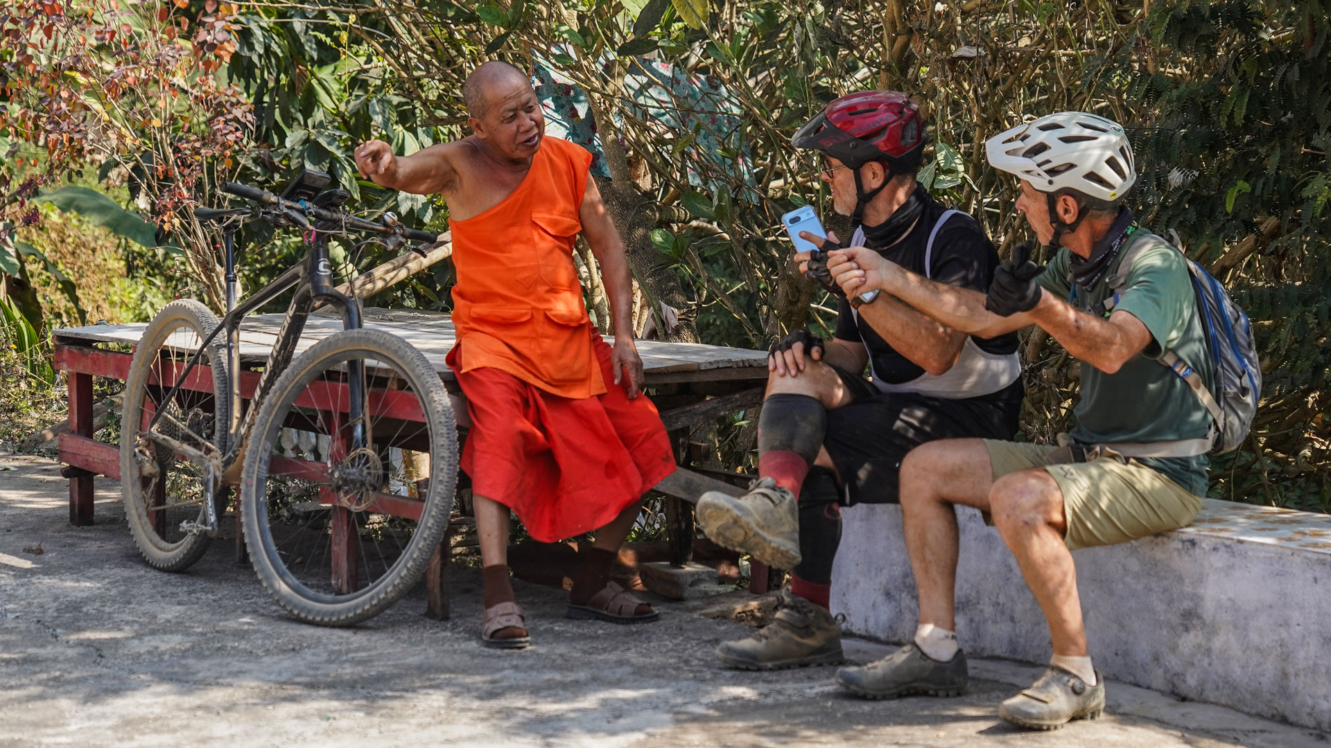 un moine bouddhiste discute avec des cyclistes