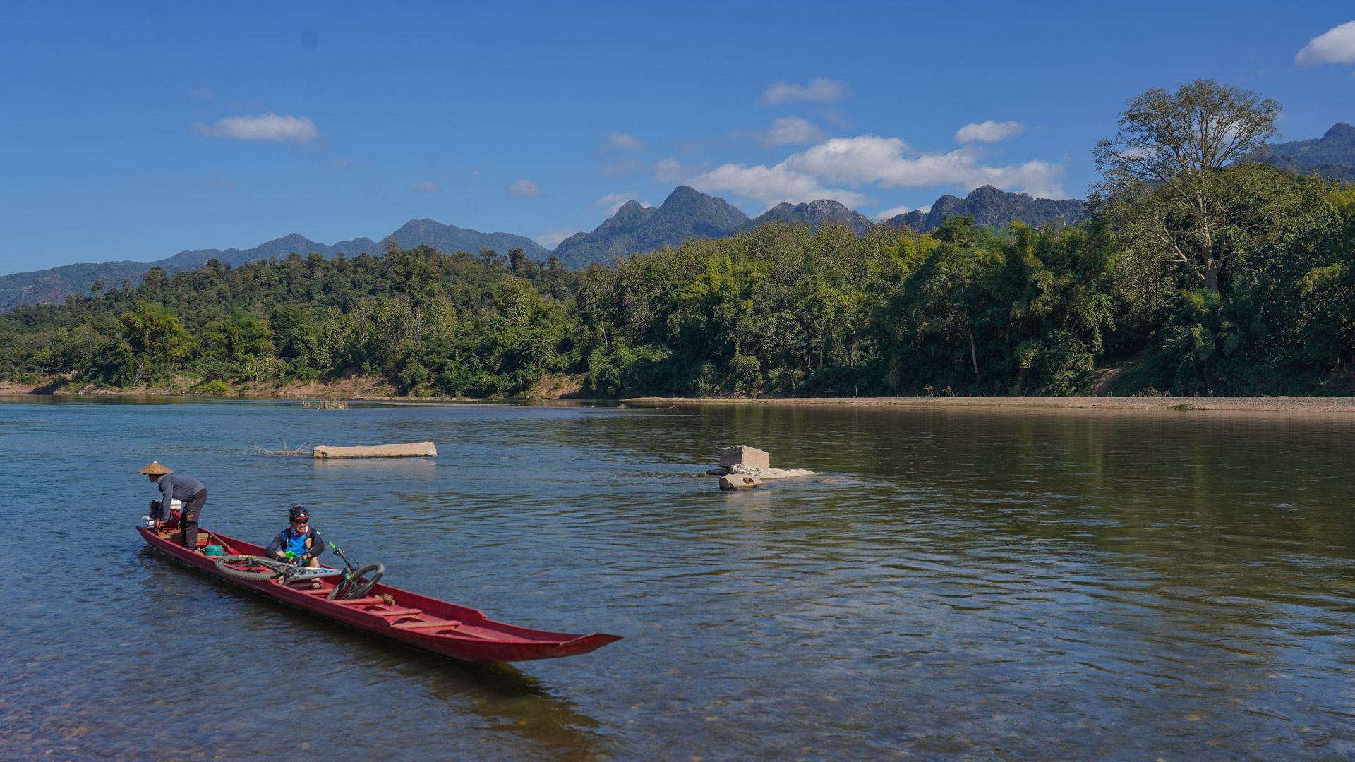 un bateau traditionnel laotien accueille un vététiste à son bord