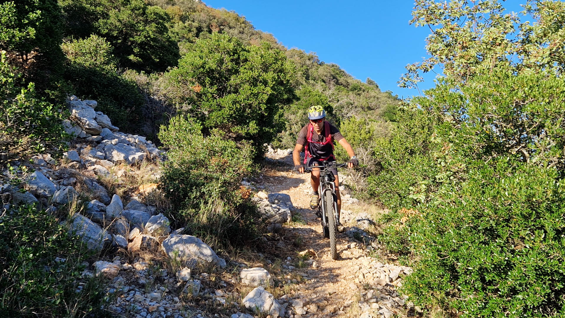 homme descend à VTT un sentier dans le Larzac